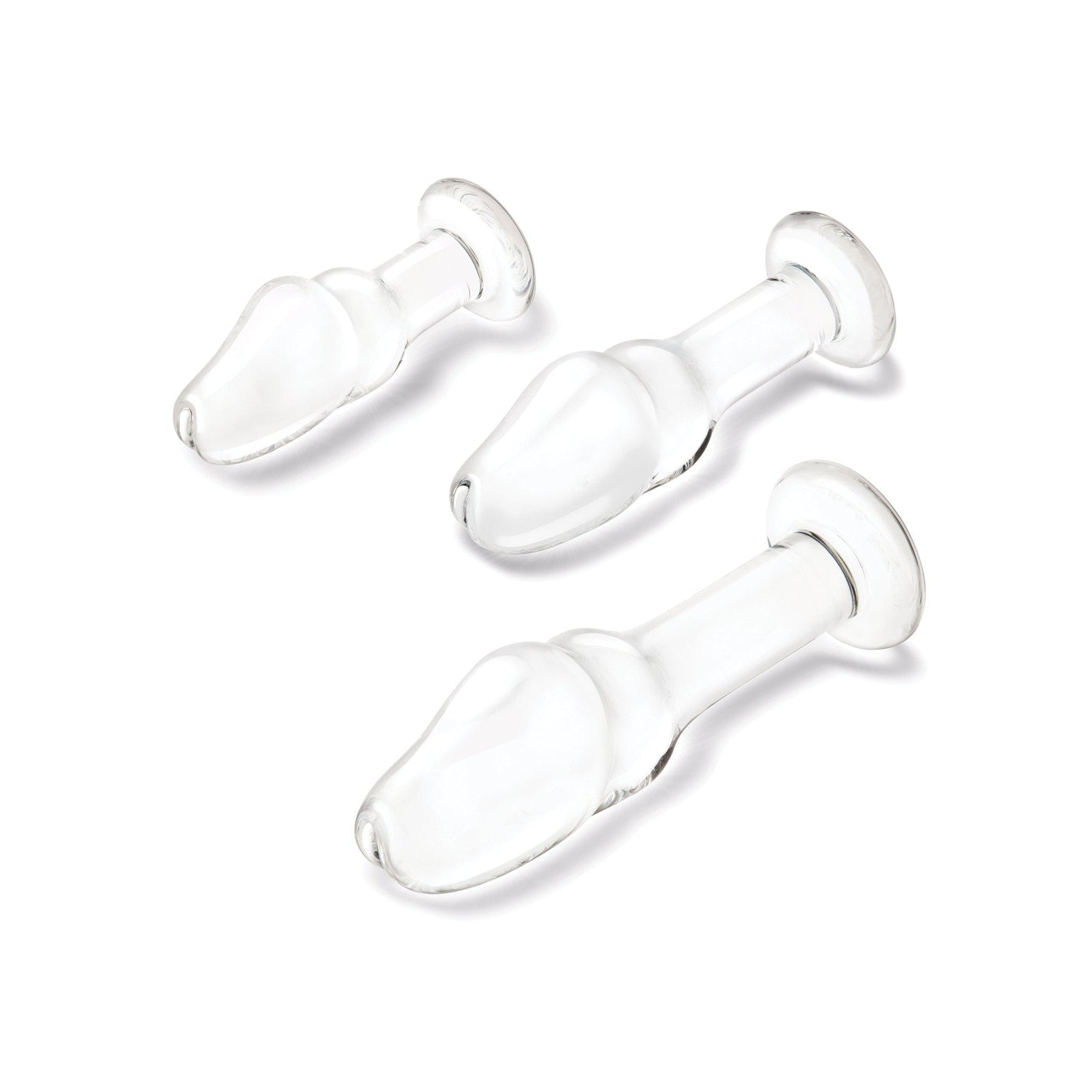 A set of three transparent, glass items in the Glas Helmet Head Anal Training Kit by Gläs features varying sizes on a white background. Each has a bulbous, helmet-shaped design with a wide end tapering to a narrow stem and flat base for temperature play exploration.