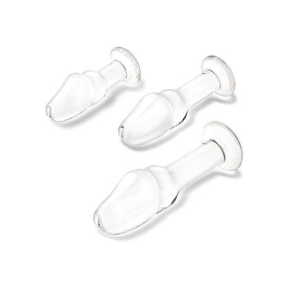 A set of three transparent, glass items in the Glas Helmet Head Anal Training Kit by Gläs features varying sizes on a white background. Each has a bulbous, helmet-shaped design with a wide end tapering to a narrow stem and flat base for temperature play exploration.