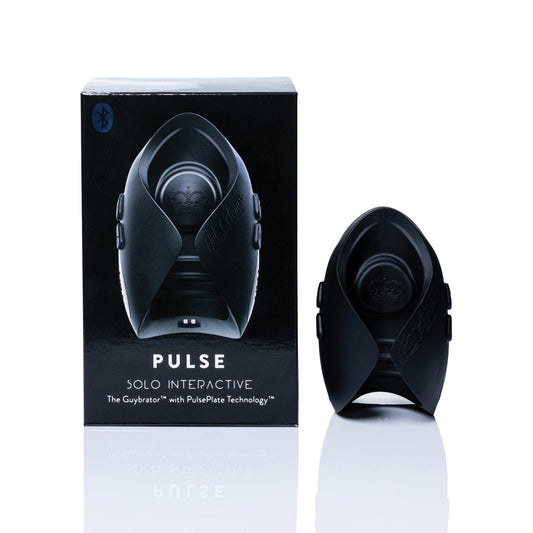 A small black device with contoured edges sits beside a matching box labeled Hot Octopuss Pulse Solo Interactive HO22, featuring the Bluetooth symbol. Known as The Guybrator, this interactive toy offers smartphone connectivity and hands-free pleasure with PulsePlate Technology.