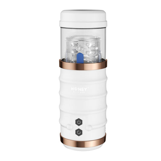 The Warrior Auto Thrusting Male Masturbator by Honey Play Box is a portable white pleasure product with a transparent top and elegant rose gold accents, designed for convenience and featuring intuitive controls for on-the-go use.