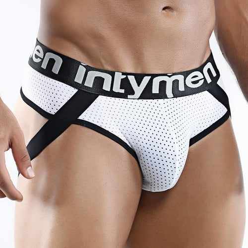 A male torso displays an Intymen Game Jockstrap, featuring a white mesh design and a bold black waistband with the Intymen logo. Black support straps add style, while a neutral background highlights the seductive appeal of this piece.