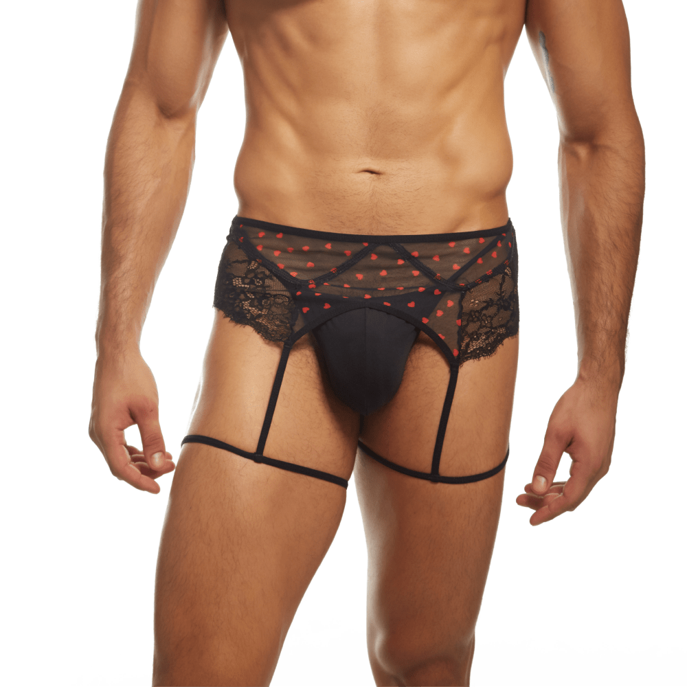 A person dons the Secret Male Flower Laced Peek-a-boo Lingerie with hearts, featuring romantic black lace, red heart patterns, and garter straps. The attire highlights a sheer waistband and matching accessories on a neutral background, making it ideal for Valentines Day.
