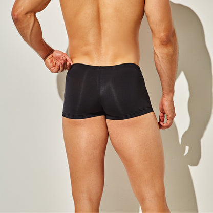 A person stands against a plain background wearing Intymen Star Pouch Boxer Trunk Underwear, showcasing their back and legs. A slight shadow accentuates the soft, stretchy fabric and spacious pouch designed by Intymen for ultimate comfort.
