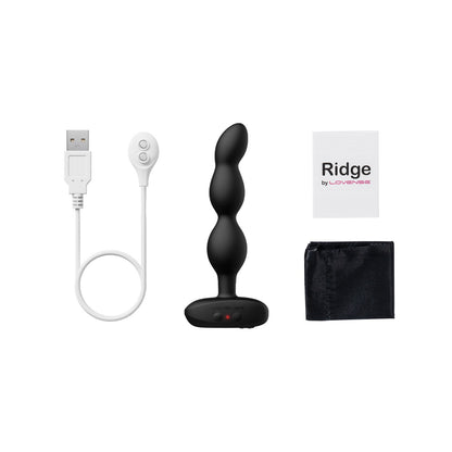 The Lovense Ridge Bumpy Anal Plug, a black vibrating plug with three bulbs and a base, is displayed with a USB charging cable, remote for app control, sleek black pouch, and information insert labeled Ridge by Lovense.