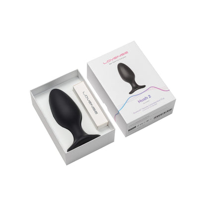 The image shows the Lovense Hush 2 Butt Plug in black, crafted from 100% silicone, partly tucked into its stylish packaging. The discreet white box features a prominent product image on the lid, highlighting its role as a quiet companion for intimate experiences.