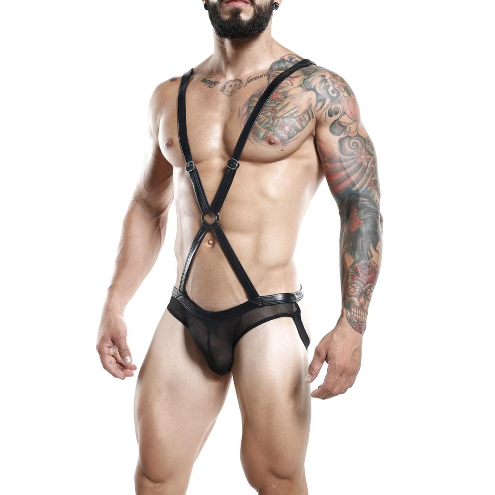 A muscular man showcases the Miami Jock Body Suit, a black leather strappy harness paired with sheer underwear. Tattoos cover his arms as he poses confidently against a white background, radiating bold and edgy allure.