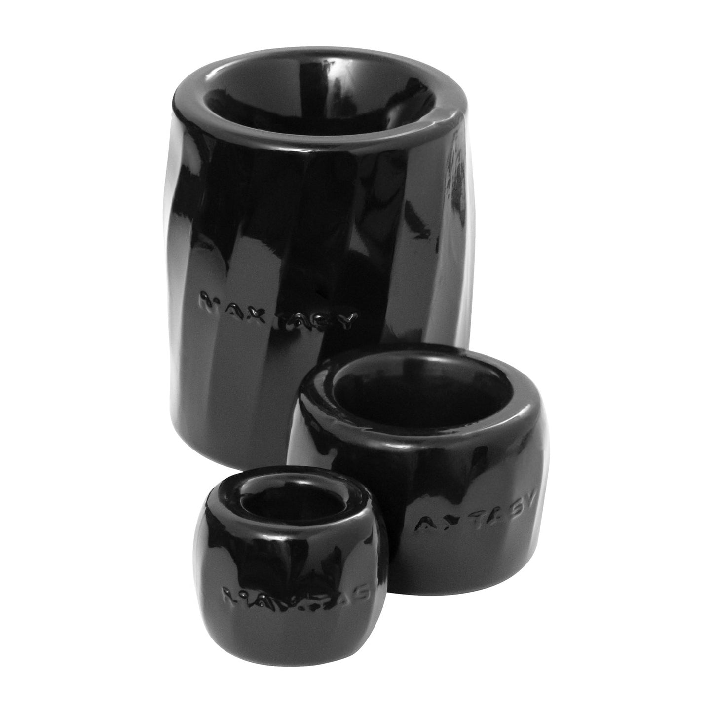 Three black, glossy ceramic Maxtasy Performance Rings in varying sizes are stacked together. Made from body-safe materials, each features a cylindrical shape with a slightly rounded lip and subtle engraved text near the base, boasting a sleek, modern design.