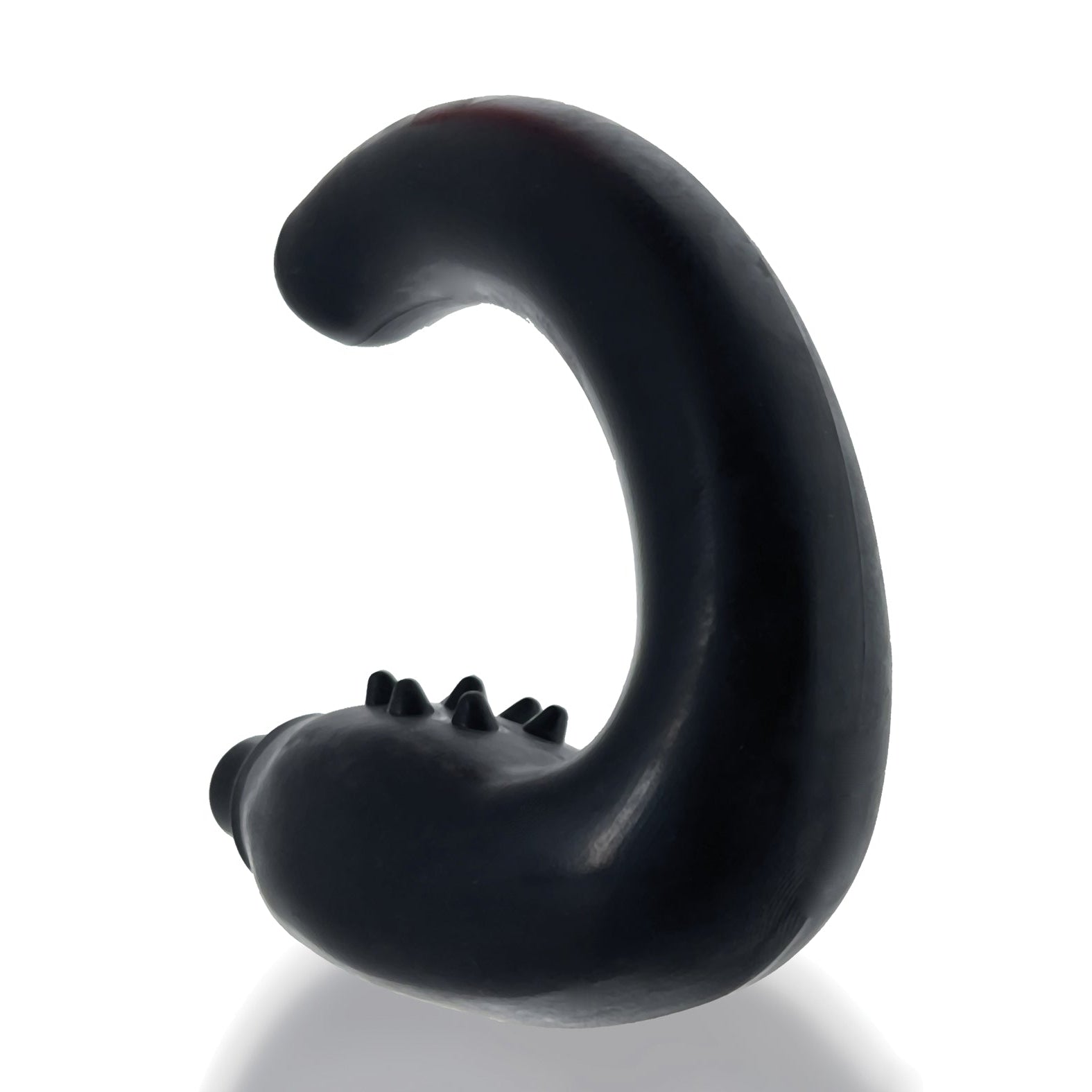 A black S-shaped object with small protrusions along its curve stands upright on a reflective surface, resembling the sleek design of a Hunky Junk Hummer Vibe Prostate Pegger, set against a plain white background.