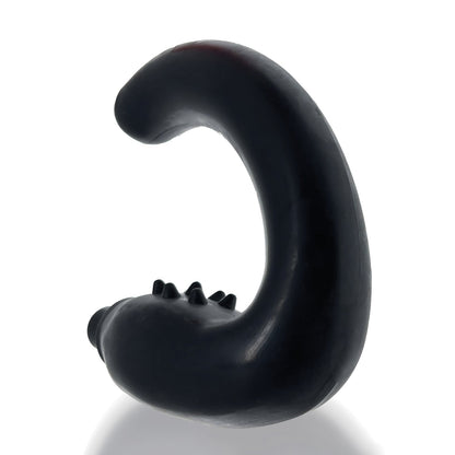 A black S-shaped object with small protrusions along its curve stands upright on a reflective surface, resembling the sleek design of a Hunky Junk Hummer Vibe Prostate Pegger, set against a plain white background.