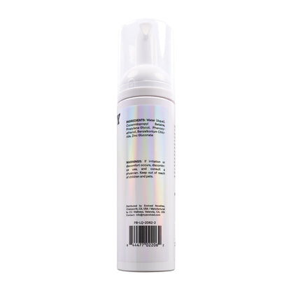 The Playboy Pleasure Clean Foaming Toy Cleaner by Playboy is packaged in a sleek white cylindrical bottle with a minimalist design and a pump dispenser. Although its ingredient and warning labels can be hard to read due to lighting, it ensures safe use with its gentle formula.