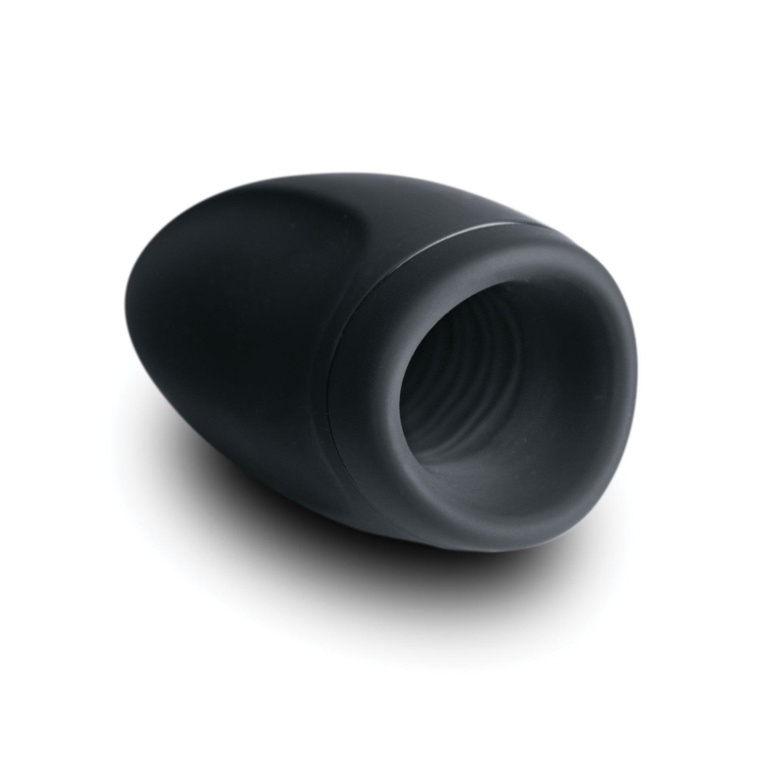The Rocks Off Torrent Rechargeable Stroker by Rocks Off is a small, smooth, black device with a rounded, oval shape and a hollow, ribbed interior. It sits at an angle on the white surface below, casting a subtle shadow.