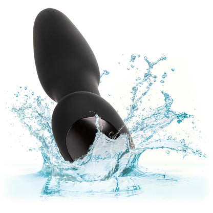 The Bionic Pressure Rimming Probe by California Exotic Novelties, shaped like a water droplet, vibrates dynamically against a white background as it splashes into clear water. Water droplets scatter around it, conveying motion and freshness.
