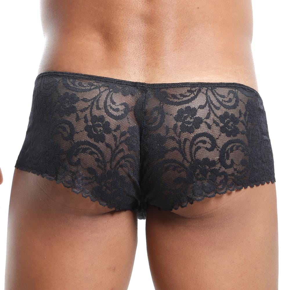 Someone is wearing the Secret Male Slip Bikini by Secret Male, featuring black lace with a floral pattern and contoured pouch. The back view emphasizes the intricate design of the sheer fabric.