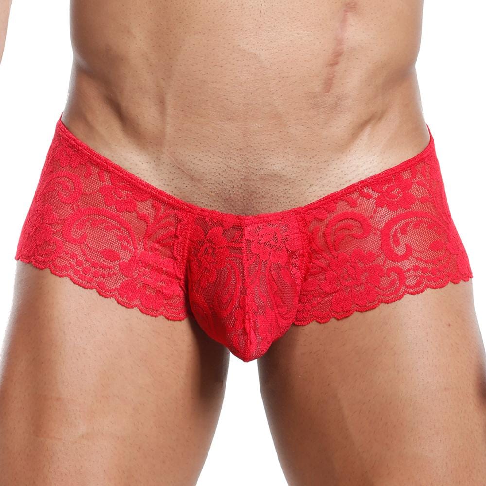 A person models Secret Males Slip Bikini, showcasing a red lace design with an intricate floral pattern and contoured pouch, ensuring a flexible fit. The image highlights the wearers toned abdomen and legs.