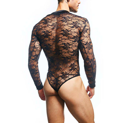 A man models the Secret Male Mens Lingerie Sexy Bodysuit against a white background, showcasing its body-hugging fit. The black lace is sheer and alluring, with an intricate floral pattern that accentuates his contours.