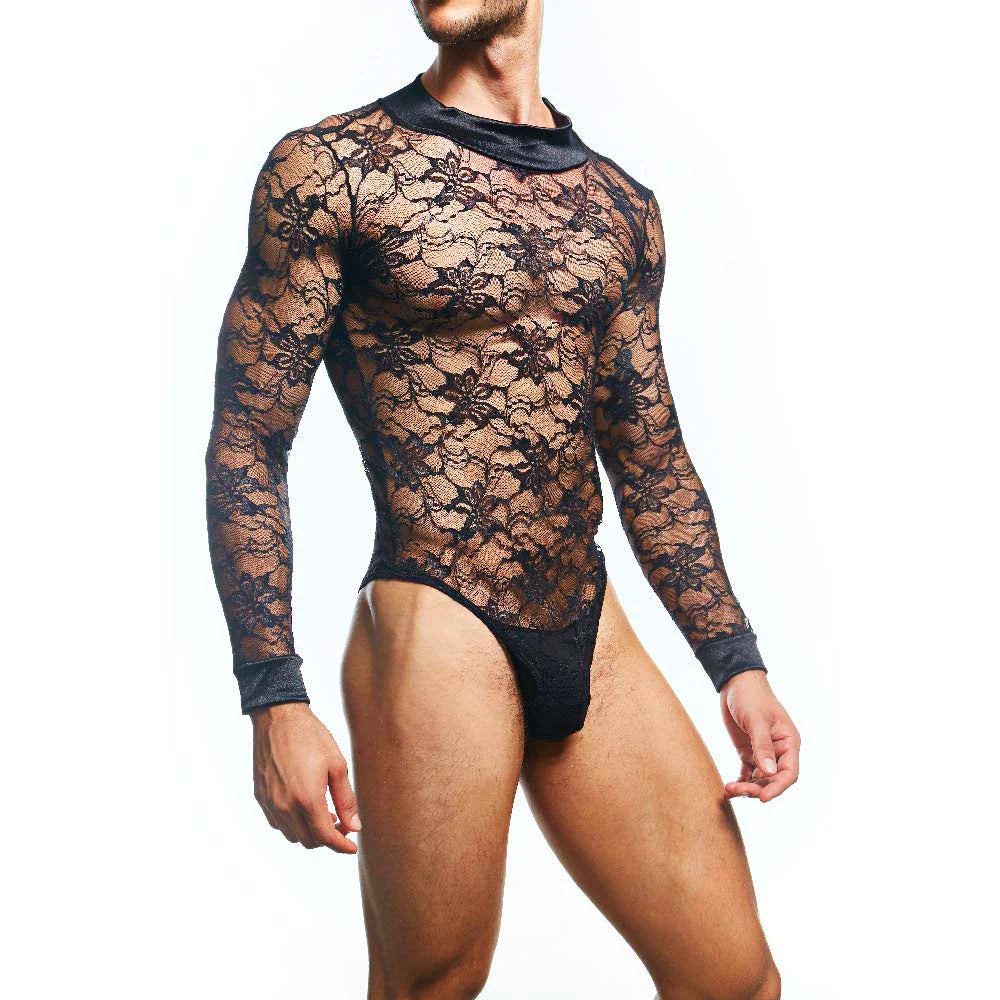 A person wearing the Secret Male Mens Lingerie Sexy Bodysuit, featuring a long-sleeved, body-hugging fit and high neckline. Black opaque accents highlight the neck and cuffs, while its floral lace pattern with high-cut legs stands out against a plain white background.