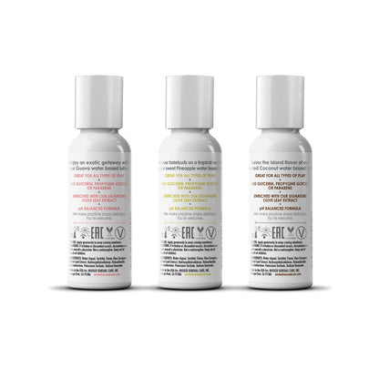 Three white bottles from Wickeds Tropical Trio Travel Size Flavored Lubes, featuring Coconut Water-based, vegan, and cruelty-free products with colorful labels displaying benefits, ingredients, and pH balance. They are neatly aligned against a white background.