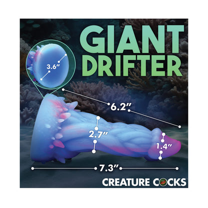 Illustration of a blue and purple jellyfish-like creature, similar to the Creature Cocks Nomura Jellyfish Silicone Dildo, with a wide, textured base and segmented body. Text reads Giant Drifter with dimensions: 6.2, 3.6, 2.7, 7.3, 1.4. Oceanic background featuring the Creature Cocks logo at the bottom.