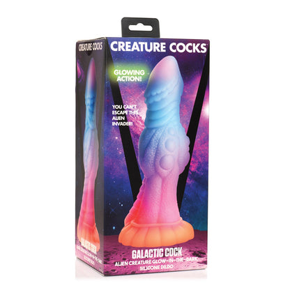 The Creature Cocks Galactic Cock Alien Creature Silicone Dildo features a colorful package with a purple-pink gradient that highlights its glow-in-the-dark feature. Its space-themed backdrop adds allure to this textured pleasure toy, promising out-of-this-world experiences.