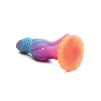 The Creature Cocks Galactic Cock Alien Creature Silicone Dildo is a colorful silicone toy with a textured surface, offering a gradient of blue, purple, and pink hues. It glows in the dark and has a stable flat orange base.