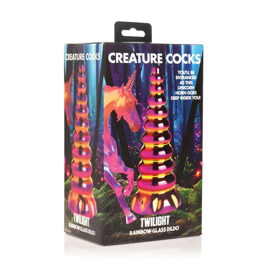 The Creature Cocks Twilight Rainbow Glass Dildo comes in a box featuring its colorful dildo image and a glowing unicorn in a mystical forest, ideal for those enchanted by borosilicate glass and the allure of temperature play.