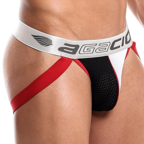 A person models the Agacio Dont Stop Jockstrap, featuring a red and black athletic design with a bold white waistband displaying the Agacio logo. The mesh fabric and supportive red straps emphasize its sporty look.