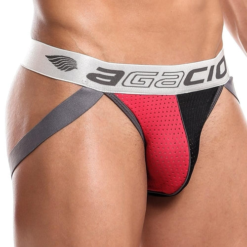A close-up shows the eye-catching design of the Agacio Dont Stop Jockstrap, featuring striking red and black colors with supportive gray side straps and a silver waistband displaying the Agacio logo. Its perforated fabric texture stands out against a plain white background, enhancing its appeal.