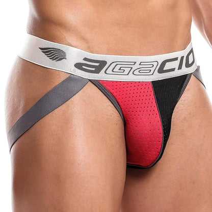 A close-up shows the eye-catching design of the Agacio Dont Stop Jockstrap, featuring striking red and black colors with supportive gray side straps and a silver waistband displaying the Agacio logo. Its perforated fabric texture stands out against a plain white background, enhancing its appeal.