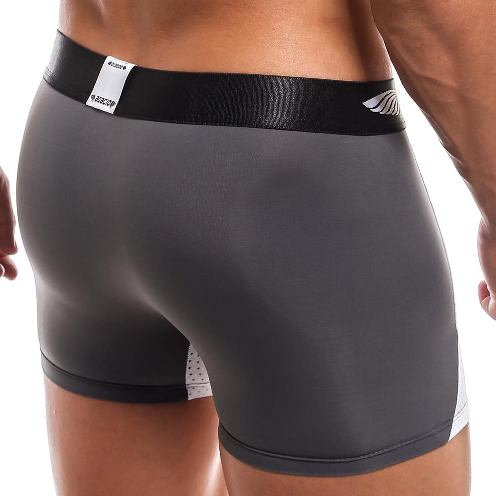 A person is shown from the back wearing Agacio Beat It Boxer in gray and black, featuring a black waistband. The smooth, comfy fabric and form-fitting design enhance their look, complete with a small tag.