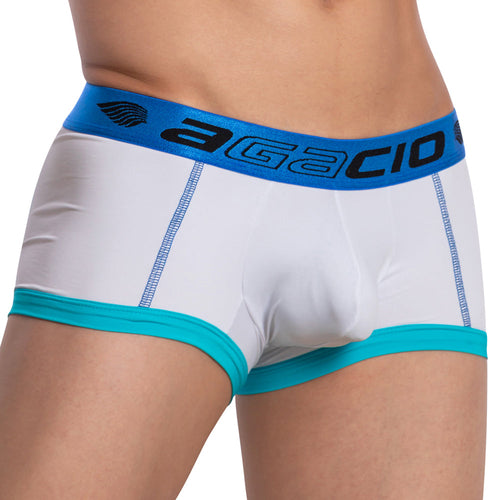 A person wears Agacio Stretch Boxer Trunk in white and turquoise, featuring a blue waistband with Agacio branding. The double-stitched pouch enhances comfort, centering attention on the lower torso and underwear with no visible background.