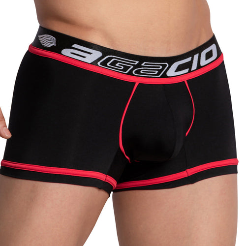 A person wearing the Agacio Bi-color Boxer Trunk, featuring sleek black fabric with red trim and an elastic branded waistband. The design hugs their tan skin snugly with stylish stitching.