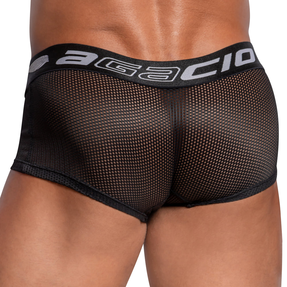 A close-up view of a person wearing Agacio Sheer Sides Boxer Trunk in black, showcasing the textured fabric and wide elastic waistband featuring the Agacio logo, viewed from the back.