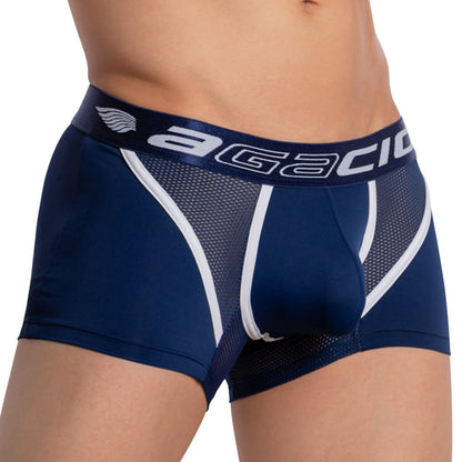 The photo highlights a person wearing the Agacio Strapped Piping Boxer Trunk—dark blue with white accents. The waistband features Agacio, focusing on comfort, breathability, and style as it captures only the lower torso and upper thighs.