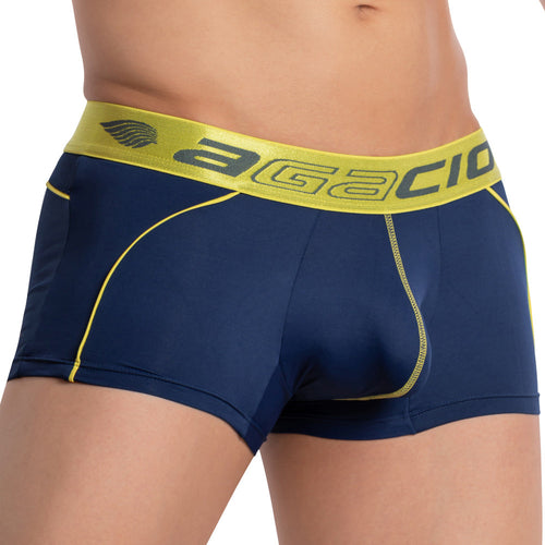 A person wearing Agacio Centerseam Bulge Boxer Trunk displays a lime green waistband with the brand name in navy blue, complete with yellow stitching for style and comfort.