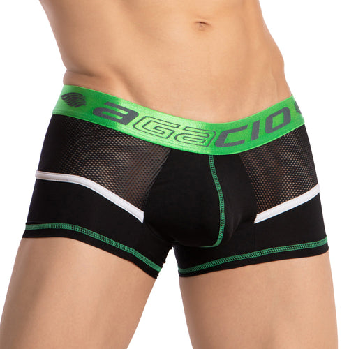 Someone is wearing the Agacio Multi Color Piping Boxer Trunk, featuring black and green mesh with a wide green waistband displaying AGACIO in bold letters. The design includes vibrant multi-color piping, white accents, and a supportive pouch made from a premium fabric blend for comfort.