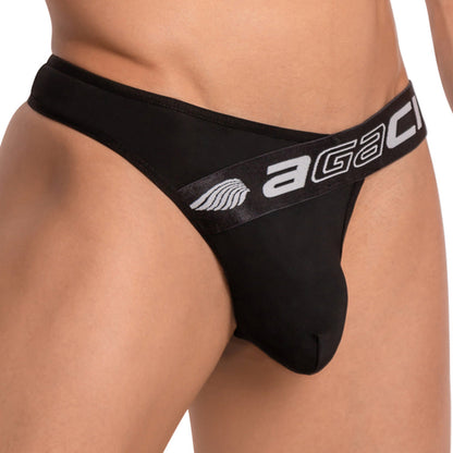 A close-up image shows someone wearing the Agacio Deep Sea Thong with a branded AGACI waistband and wing logo. The focus is on the waist and hip, highlighting its design and fit, made from light as air fabric for ultimate comfort.