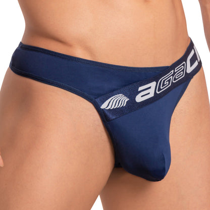 The Agacio Deep Sea Thong is a navy men’s jockstrap with a wide waistband featuring the brand name Agacio in white. Made from light-as-air fabric, it offers a close fit with functional pouch support and has a small wing logo on the waistband, blending comfort and style.