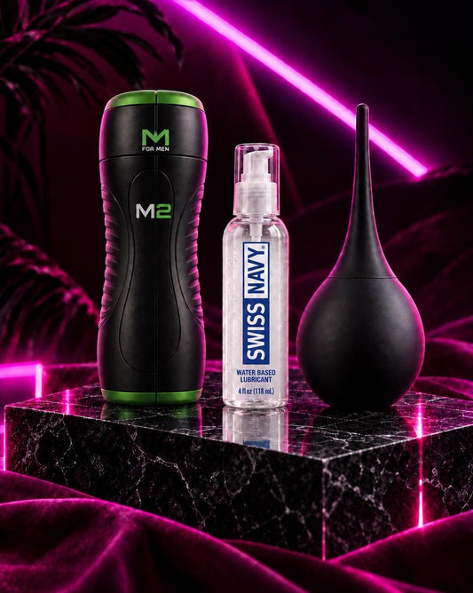 An example Just Out subscription box: a stroker, water-based lube and a douche on a marble block under pink neon