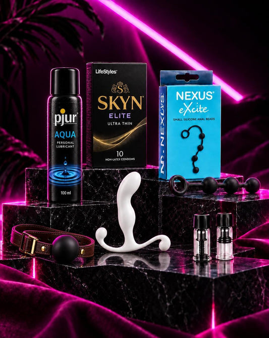 An example Out N' Proud subscription box: lube, condoms, anal beads, a prostate massager and extras on marble steps under pink neon