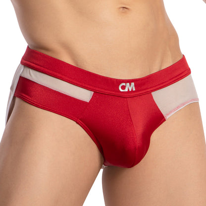 The image captures a person wearing the Cover Male Backless Beauty Jockstrap, featuring a red and white design. Made from silky, breathable fabric, it has a discreet logo on the waistband. The focus is on the lower torso and hips.