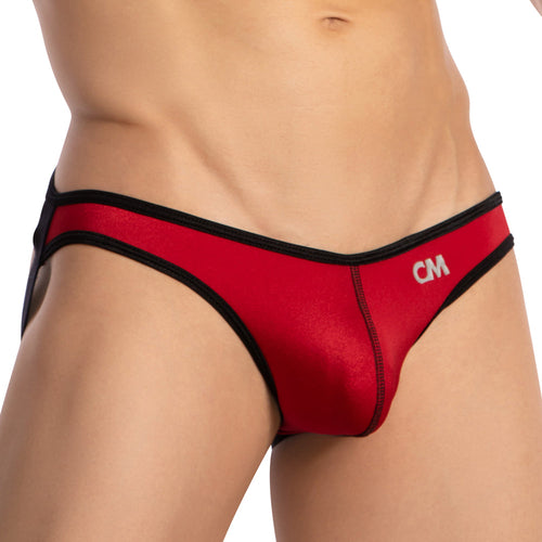 A person in a Cover Male Centerseam Open Back Jockstrap, red with black trim and CM initials on the side. The photo highlights the lower torso and hip area, showcasing its breathable fabric for comfort and style.