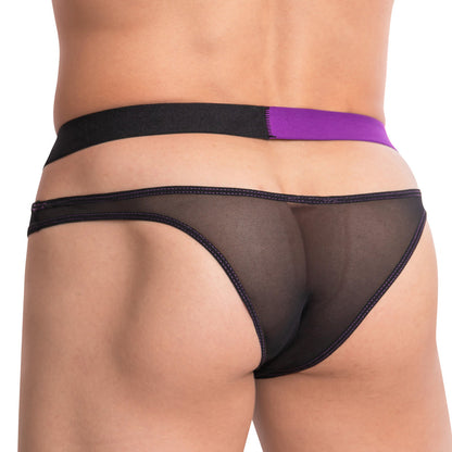 Someone showcases the Cover Male The Spilt Bikini, a sheer black jockstrap with purple trim and a thick waistband, emphasizing its low-rise fit. The photo highlights the lower back and upper legs against a plain background, accentuating the unique two-tone design by Cover Male.