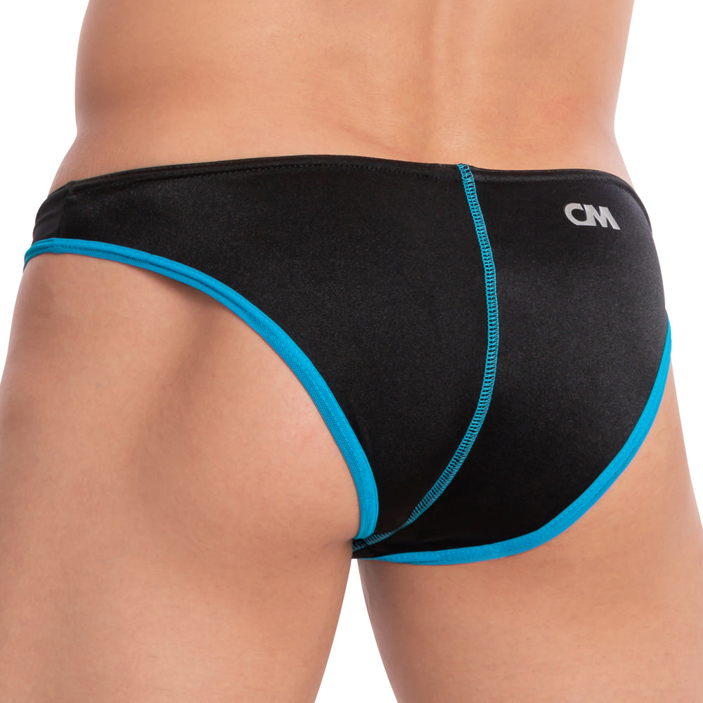 A person is wearing the Cover Male Arctic Bikini with a two-tone design, featuring blue accents and CM initials on the waistband. The stylish swimwear highlights blue trimming and contrasting seams on a white background.