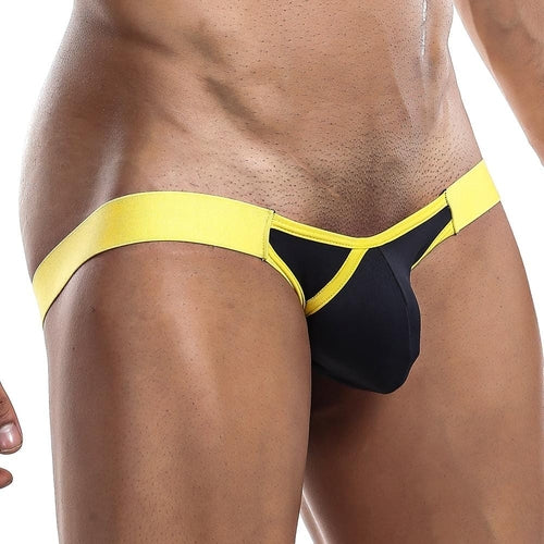 A person is wearing the black and yellow Playmaker Jockstrap by Intymen, showcasing its mesh fabric in front and side views, accentuating their manly features and fit physique against a medium brown skin tone.