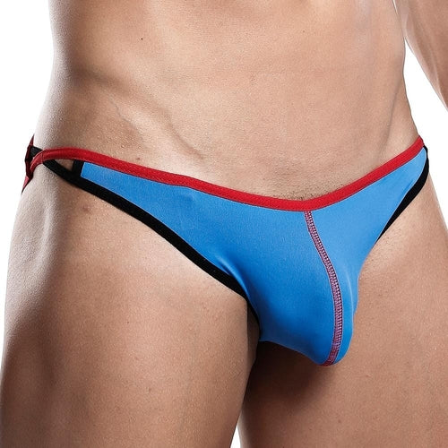 A person wearing a Daddy Jockstrap, featuring blue and red with black trim, is shown waist down. The design has side cut-outs and a contoured pouch for a sexy fit, highlighting the stylish details of this eye-catching underwear by Daddy.