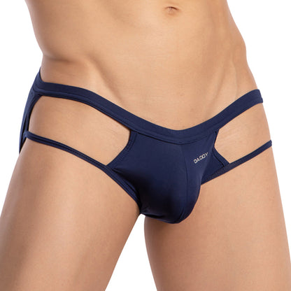 A person wears the Daddy Strapped Backless Jockstrap, featuring navy blue cut-outs and Daddy printed on the front. The image focuses closely on the midsection to highlight this provocative style from Daddy.