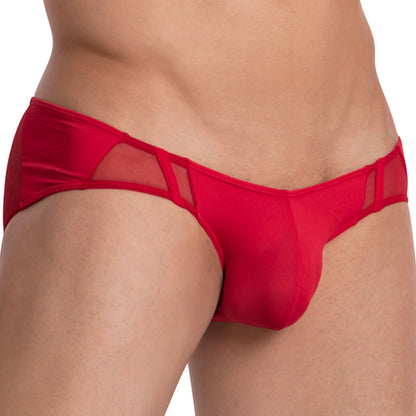 A person wears the red, semi-sheer Daddy Equality Brief, with side cut-outs and a snug fit enhanced by vertical piping. The bold color and intricate design stand out against a plain white background.