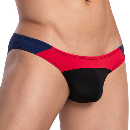 A model exhibits the Daddy Party Out Bikini, featuring a navy blue, red, and black panel design. This mens underwear by Daddy highlights the midsection with its luxurious fabric, giving a sensual allure.