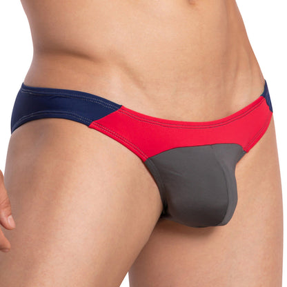 A detailed look at someone wearing the Daddy Party Out Bikini by Daddy, featuring a sensual color-block design with blue, red, and gray panels in luxurious fabric.