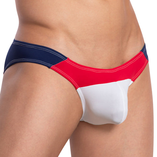 A close-up of someone wearing the Daddy Party Out Bikini from Daddy, a sensual swimsuit made of luxurious fabric with color-blocked sections in navy blue, red, and white.